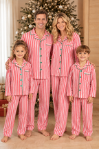 Family wearing matching red and white candy cane striped button-up Christmas pajamas with green piping