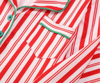 Family wearing matching red and white candy cane striped button-up Christmas pajamas with green piping - view 11