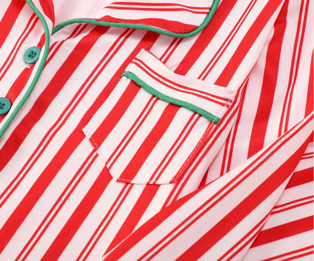 Family wearing matching red and white candy cane striped button-up Christmas pajamas with green piping - view 11