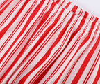 Family wearing matching red and white candy cane striped button-up Christmas pajamas with green piping - view 12