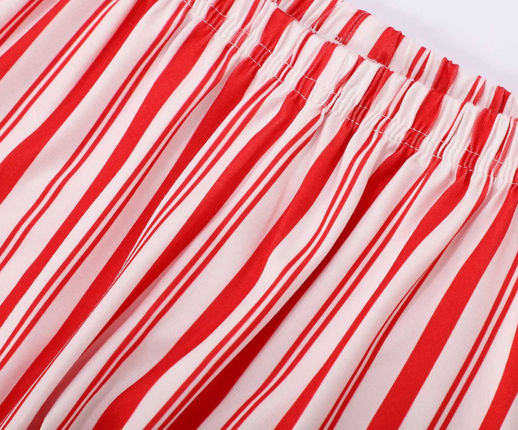 Family wearing matching red and white candy cane striped button-up Christmas pajamas with green piping - view 12