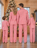 Family wearing matching red and white candy cane striped button-up Christmas pajamas with green piping - view 4