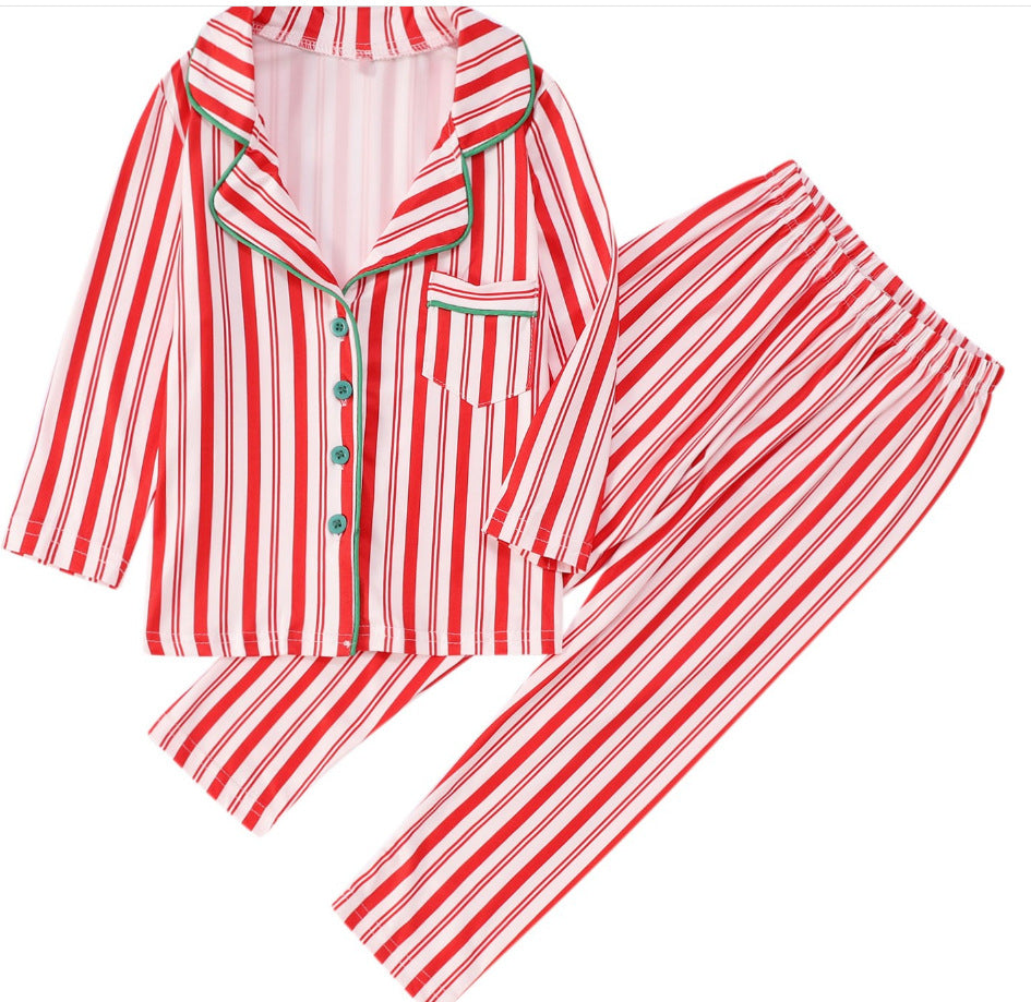 Family wearing matching red and white candy cane striped button-up Christmas pajamas with green piping - view 9