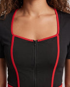 Woman wearing a black nurse costume mini dress with red piping, red cross belt, nurse cap and stethoscope - view 2