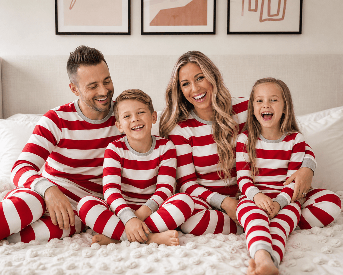 Family in matching red and white striped Christmas pajamas with gray ribbed cuffs