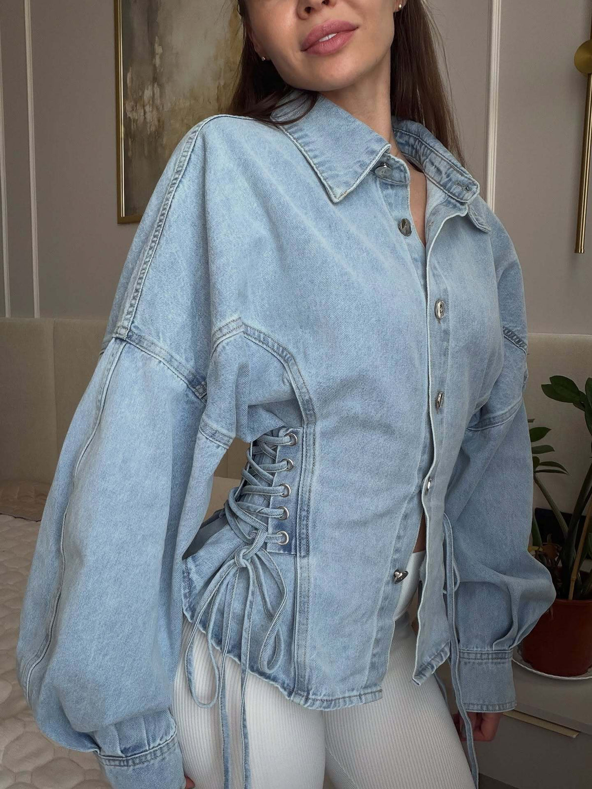 Oversized light wash denim jacket with lace-up side panels and balloon sleeves
