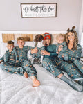 Family wearing matching green safari print Christmas pajamas