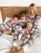 Family wearing matching Fair Isle Christmas pajamas with reindeer and snowflake print and white cuffs - view 5