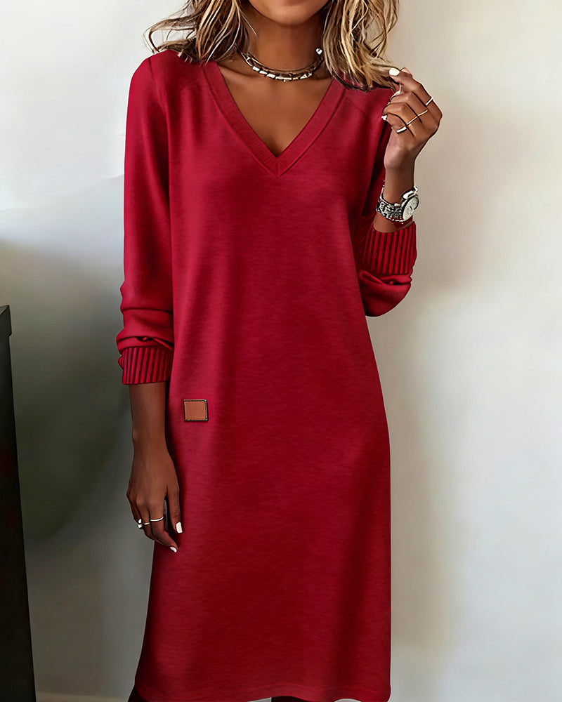 Woman wearing a relaxed V-neck midi sweater dress with raglan long sleeves and striped cuffs - view 7