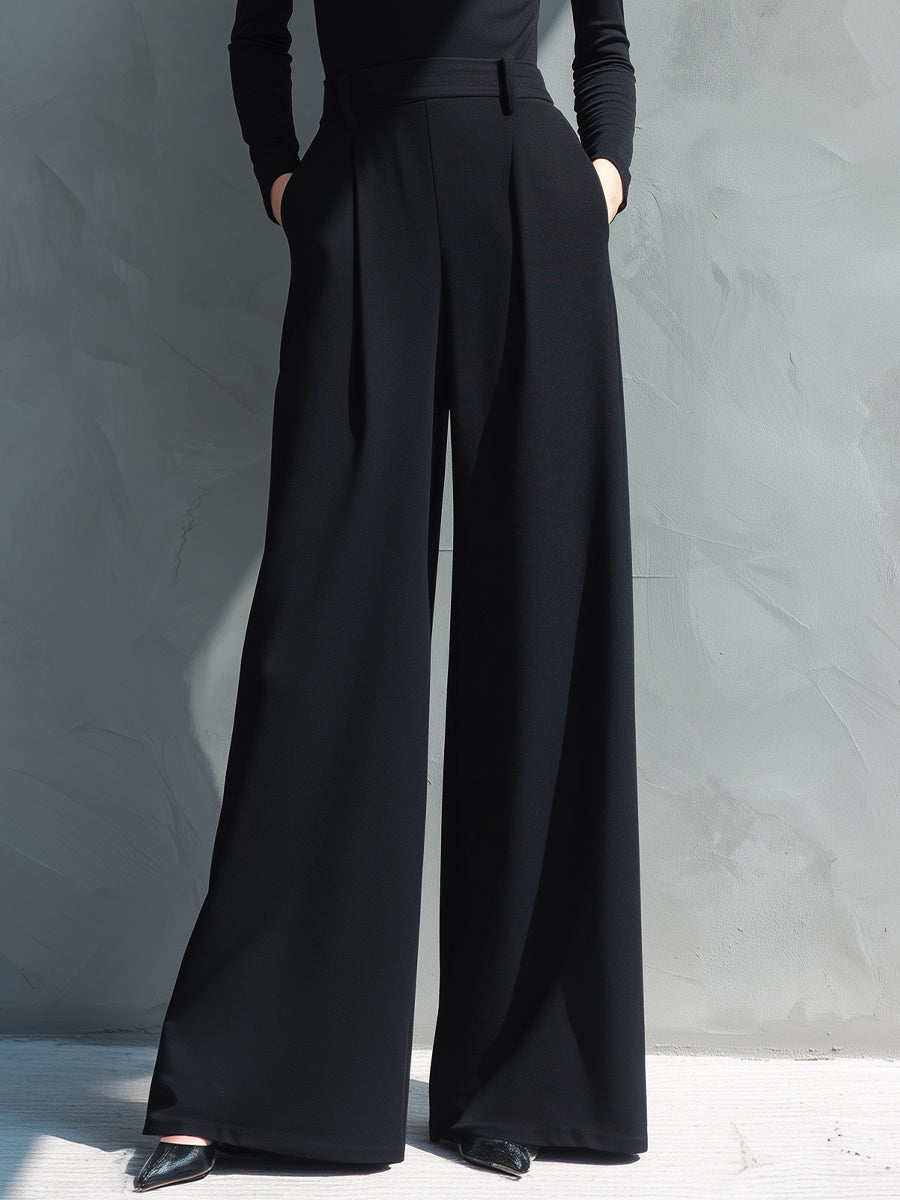 Woman in black long sleeve wide leg jumpsuit with turtleneck and pleated legs - view 3