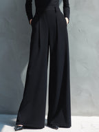 Woman in black long sleeve wide leg jumpsuit with turtleneck and pleated legs - view 3