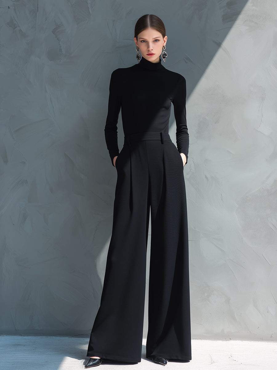 Woman in black long sleeve wide leg jumpsuit with turtleneck and pleated legs - view 4