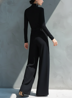 Woman in black long sleeve wide leg jumpsuit with turtleneck and pleated legs - view 5