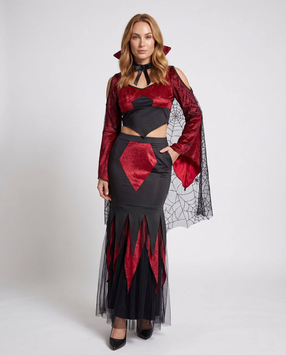 Women's two-piece vampire Halloween costume with red velvet crop top, spiderweb mesh bell sleeves and black jagged maxi skirt