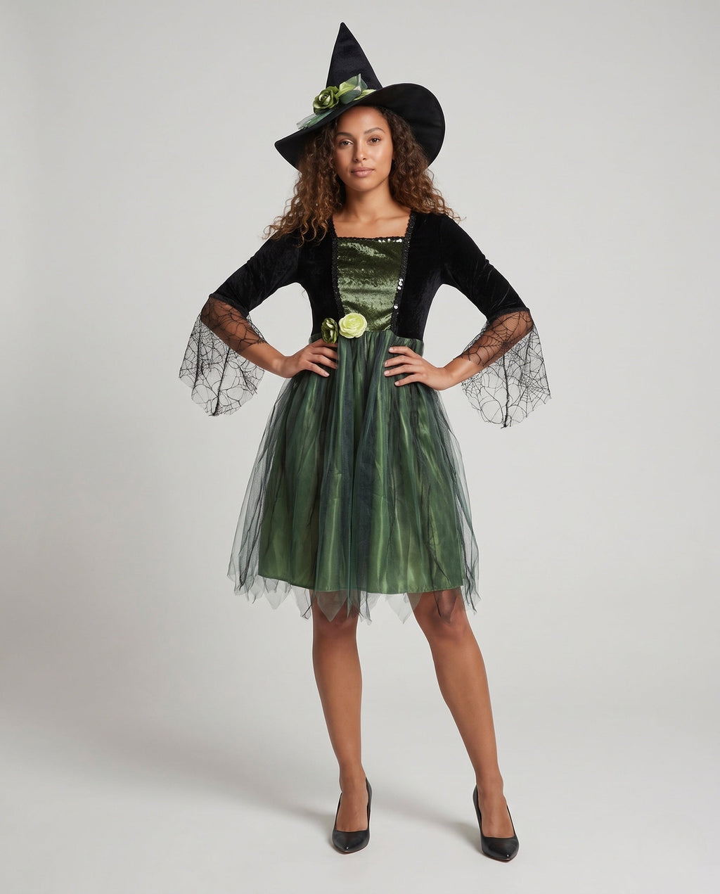 Women's witch Halloween costume with black velvet bodice, spiderweb lace bell sleeves and green tulle skirt