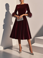 Burgundy velvet feather cocktail dress with A-line midi skirt and feather-trimmed cuffs