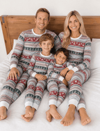 Family wearing matching gray Fair Isle Christmas pajamas with red reindeer and green tree stripes - view 12