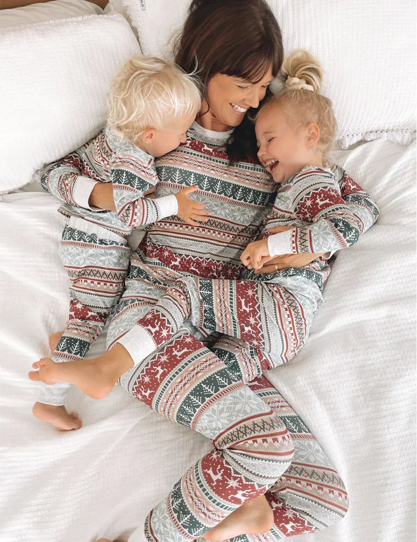 Family wearing matching gray Fair Isle Christmas pajamas with red reindeer and green tree stripes - view 13