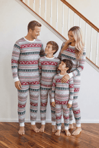 Family wearing matching gray Fair Isle Christmas pajamas with red reindeer and green tree stripes - view 3