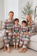 Family wearing matching gray Fair Isle Christmas pajamas with red reindeer and green tree stripes - view 5