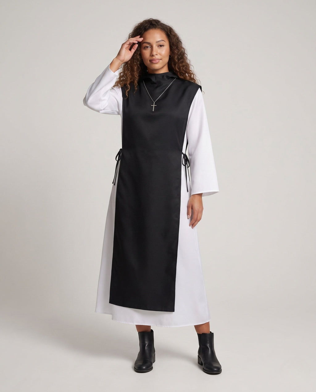 Women's nun Halloween costume with black hooded tabard over white long-sleeve robe