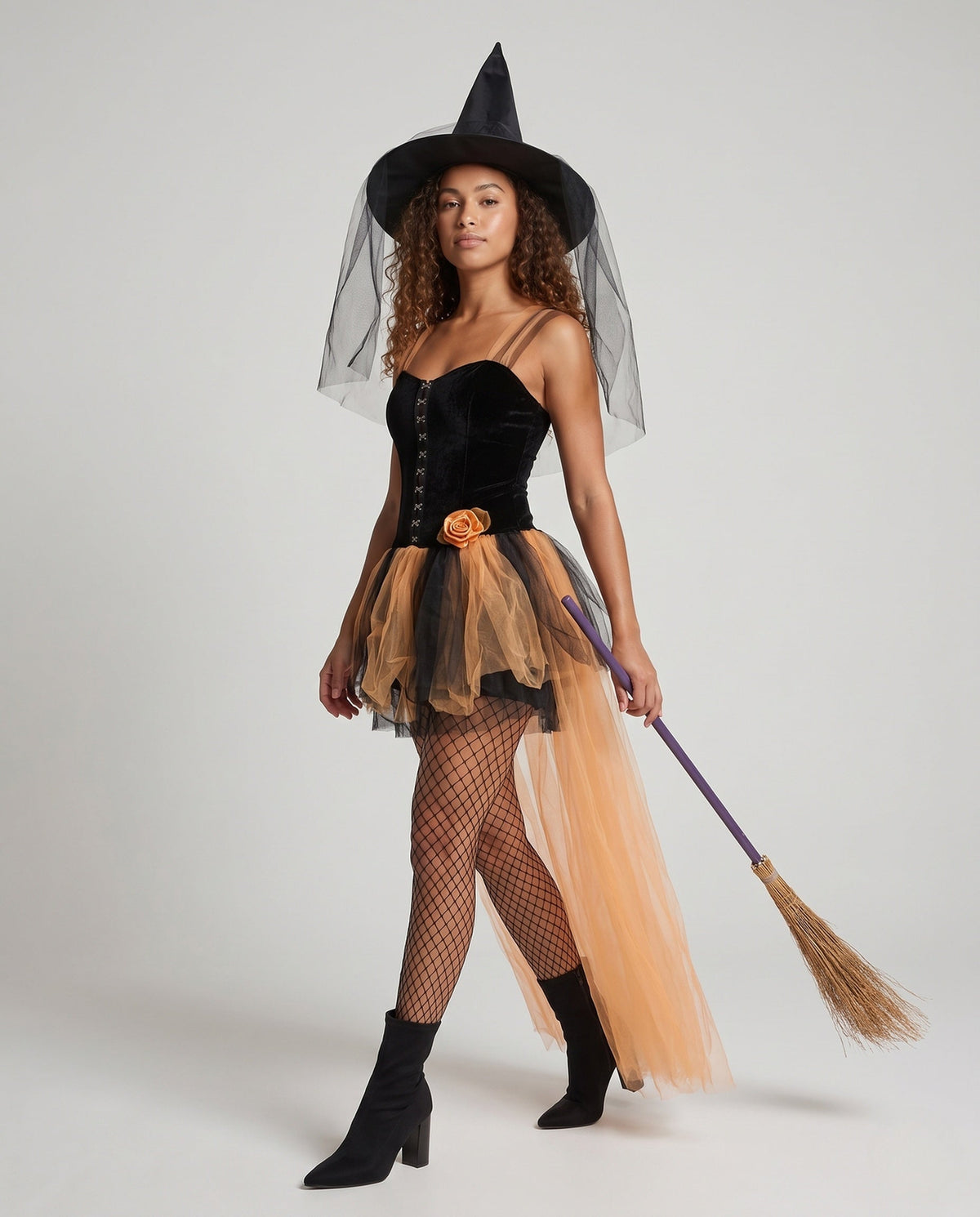 Women's witch Halloween costume with black velvet corset bodice and layered orange tulle skirt with train