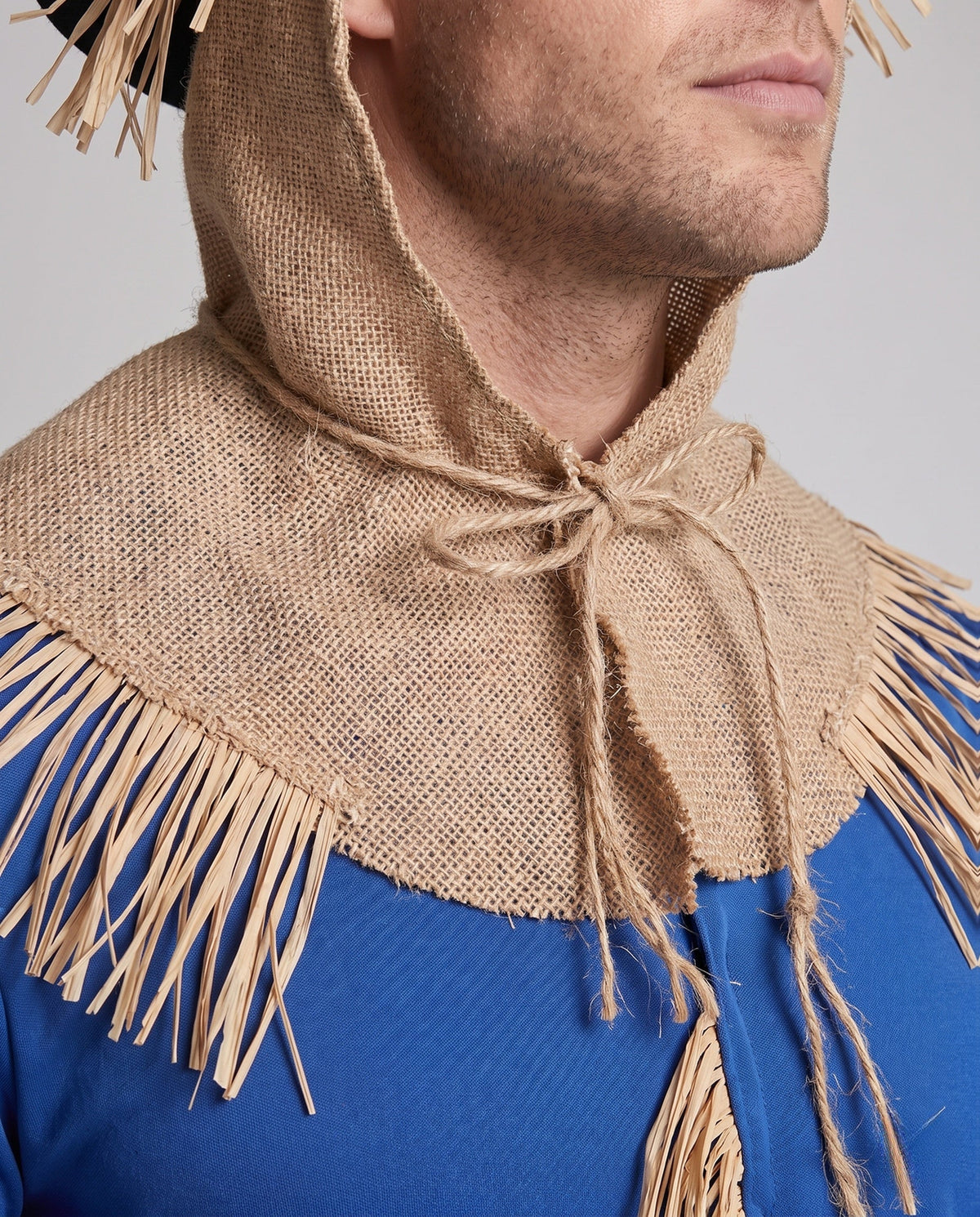 Men's scarecrow Halloween costume with blue fringed top, burlap-look hood, patched red pants, black hat and white gloves - view 2