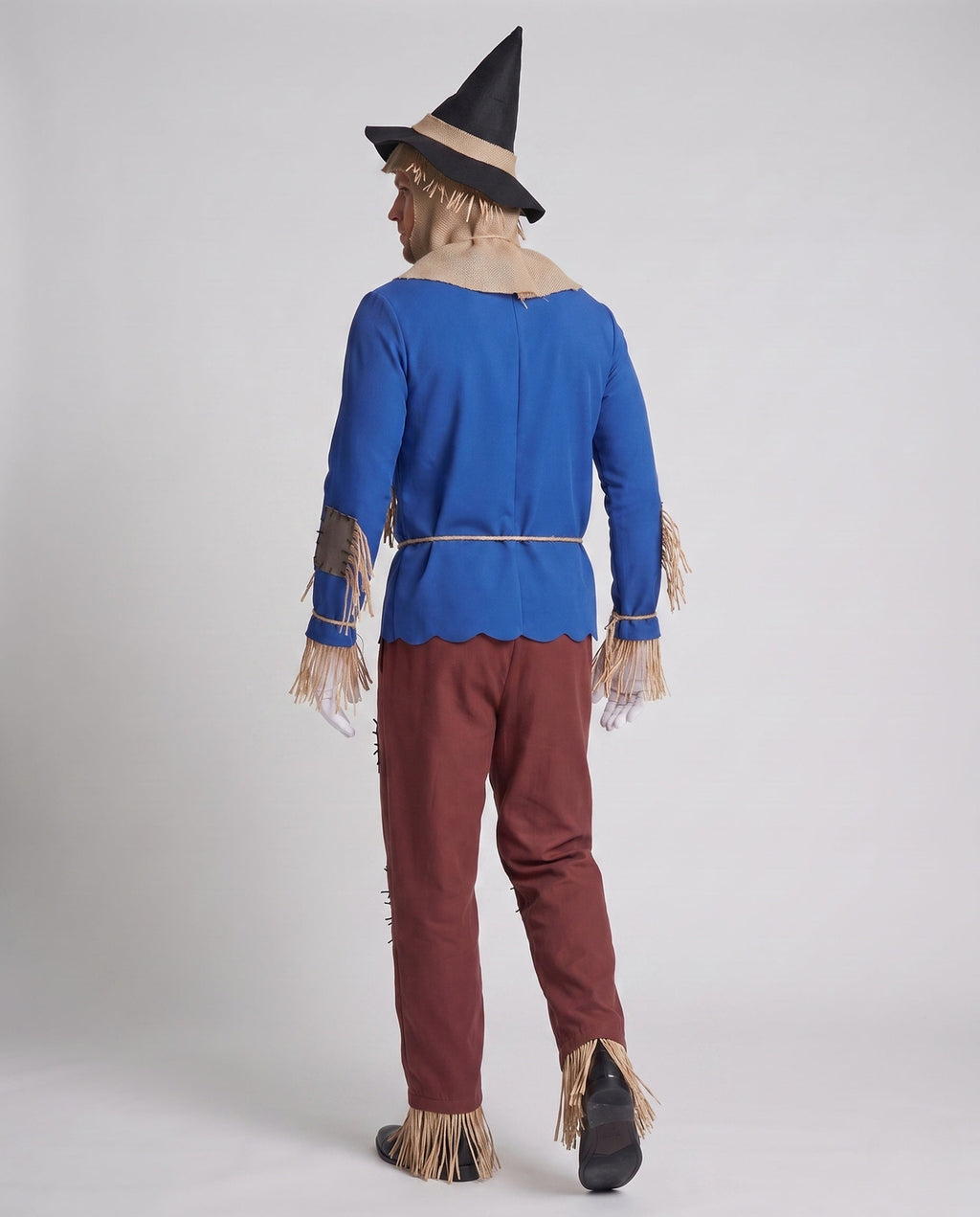 Men's scarecrow Halloween costume with blue fringed top, burlap-look hood, patched red pants, black hat and white gloves - view 3