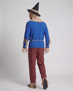 Men's scarecrow Halloween costume with blue fringed top, burlap-look hood, patched red pants, black hat and white gloves - view 3