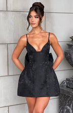 Black floral jacquard homecoming mini dress with plunging V neckline, lace-up back and oversized back bow