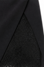 Woman wearing a fitted tuxedo-collar cocktail dress with sheer lace sleeves and lace skirt panel - view 10