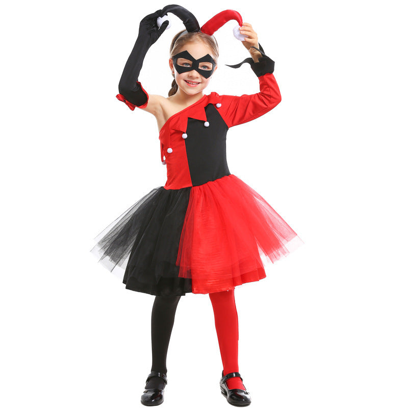 Girl wearing a red and black jester Halloween costume with one-shoulder bodice, pom-pom trim, tulle skirt and black eye mask